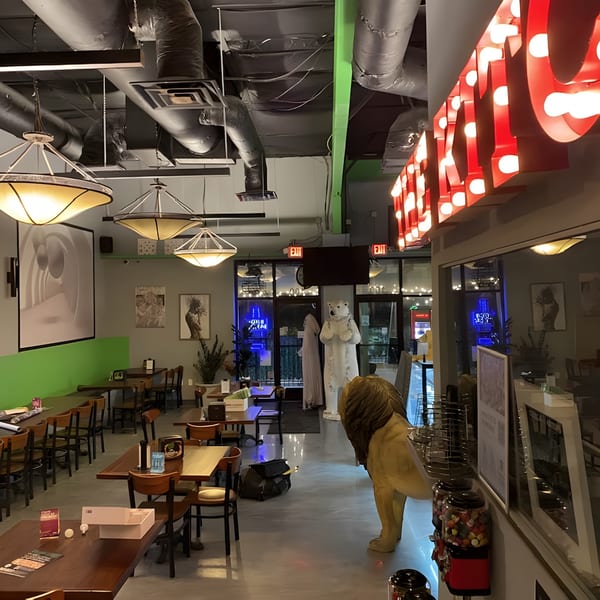 Interior of Green Fire Pizza Pooler with tables, chairs, decorative lion, and polar bear statues.