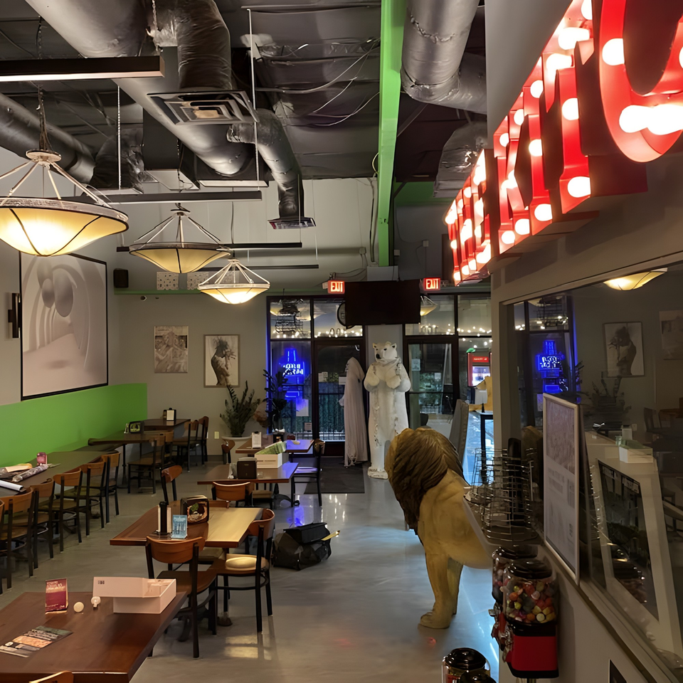 Interior of Green Fire Pizza Pooler with tables, chairs, decorative lion, and polar bear statues.